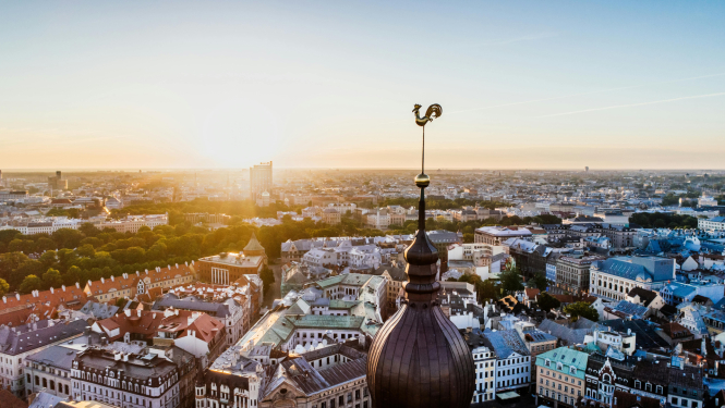 Rīgas panorāma saulrietā, priekšplānā Doma baznīcas tornis.