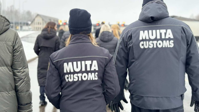 Attēlā redzamas KNAB un VID muitas amatpersonas no mugurpuses