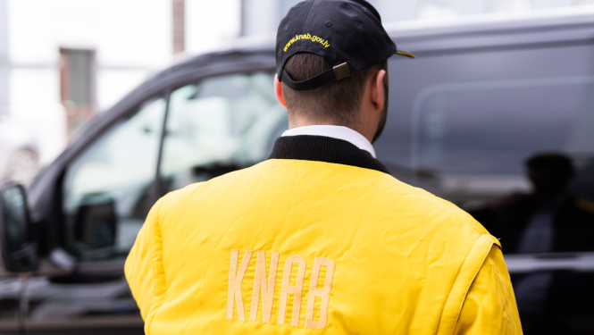 Attēlā redzama persona KNAB darbinieka formā