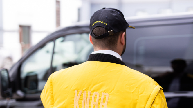 Attēlā redzama persona KNAB darbinieka formā