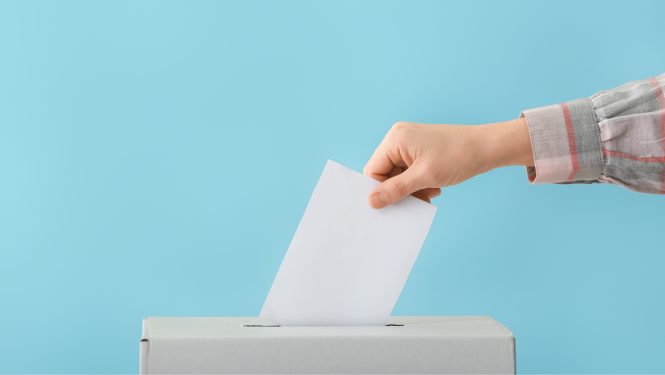 Roka tur balt aploksni, kas krīt vēlēšanu urnā