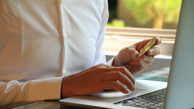 Attēlā redzama persona ar portatīvo datoru