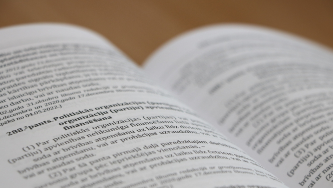 Attēlā redzams grāmatas atvērums daļā par Krimināllikuma pantu, kas attiecas uz atbildību par nelikumīgu politisko organizāciju finansēšanu