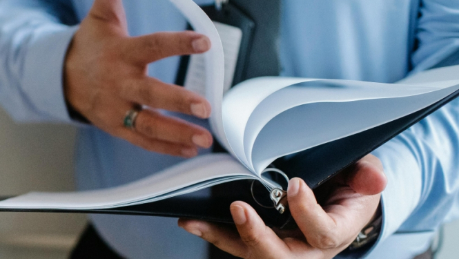 Vīrietis tur rokās dokumentu mapi