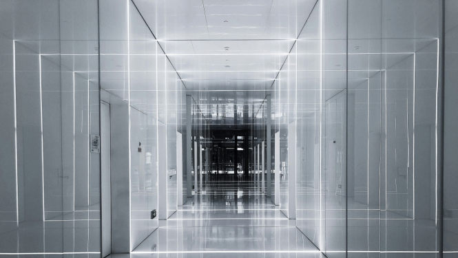 Gaiša, saspiesta telpa, kurā ar baltām gaismām radīta optiskā ilūzija par telpas platumu. Futūristiska noskaņa.